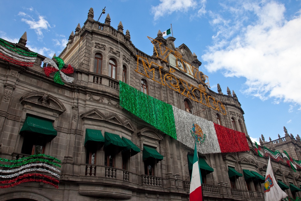 Fachada con bandera mexicana en el Zócalo de puebla